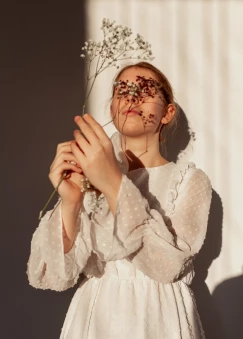 Portrait of a woman holding dried flowers to her face