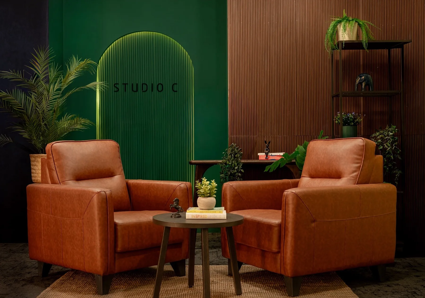 The arched green Studio C set with leather armchairs and a low table